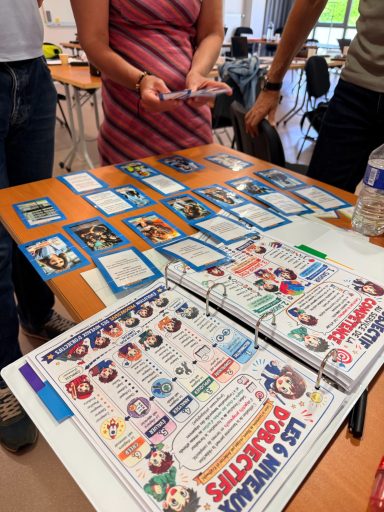 Appairage et reflexion Des personnages de cartes de jeu disposés sur une table avec des documents autour.